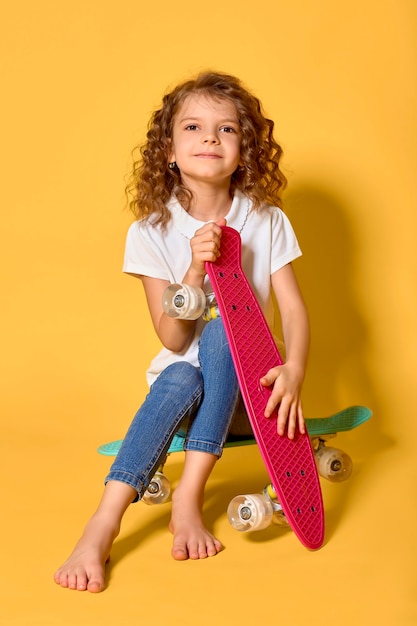 Criança ativa e feliz se divertindo com a prancha, um rosto sorridente fica de pé no skate