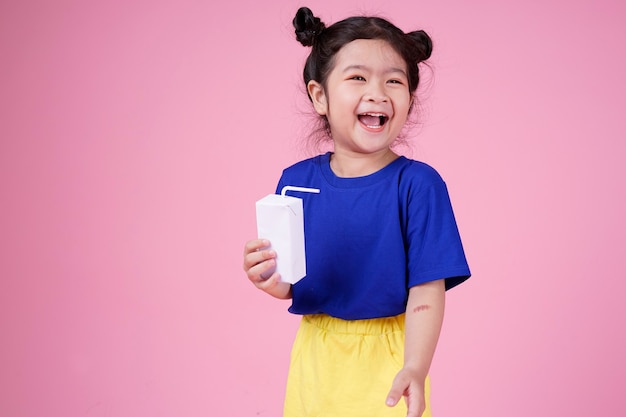 Criança bonita asiática confiante bebe caixa de leite