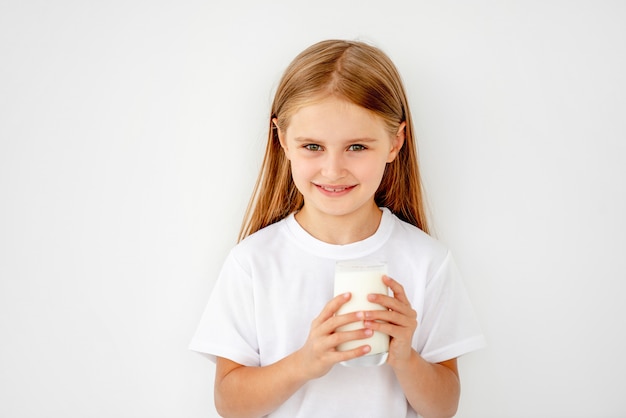 Criança bonita colegial bebendo leite quente