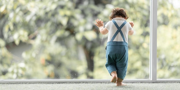 Criança bonita criança conceito de família bebê aprendendo a andar com pai e mãe para ajudar a cuidar e segurando a mão no primeiro passo com apoio dos pais da infância pequeno retrato de amor menino em casa