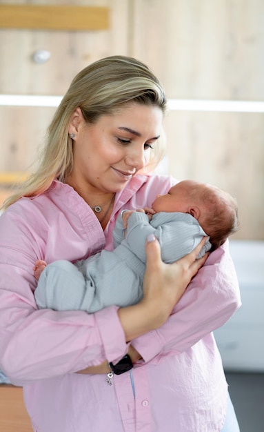 Criança bonita nas mãos da mãe Jovem mãe bonita com filho recém-nascido