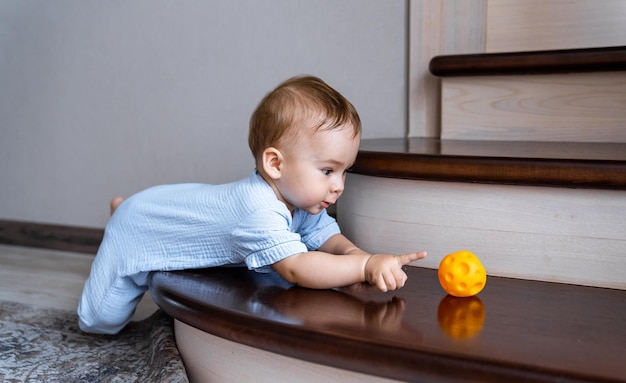 Criança bonitinha brincando com bola no chão adorável criança bonitinha se divertindo