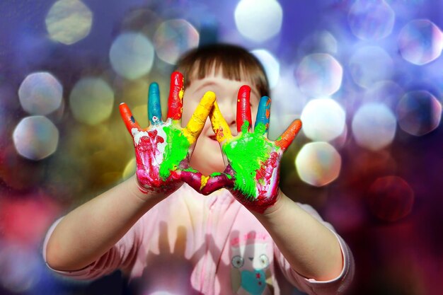 Criança bonitinha com as mãos pintadas.