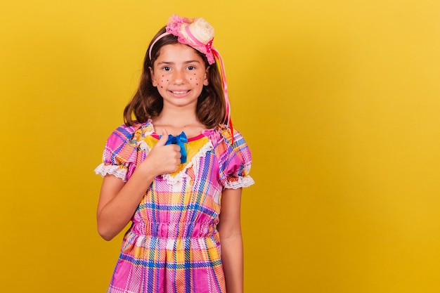 Foto criança brasileira caucasiana festa junina roupas polegar para cima aprovação afirmativa maio junho e julho festividades festa junina celebrações