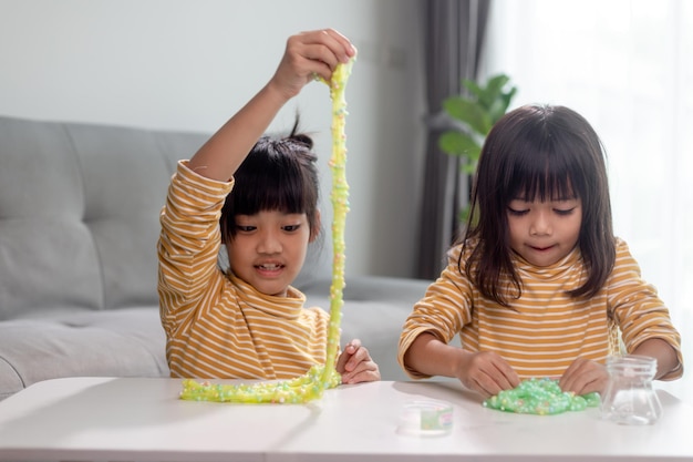 Criança brinca com goma de mascar Slime nas mãos de crianças