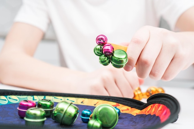 Criança brinca de brincar sentada à mesa fechada Mão de criança magnetiza e pega brinquedos coloridos de metal do prato