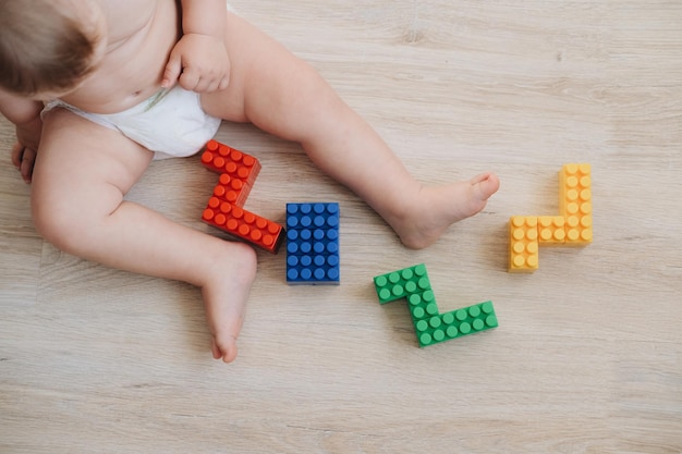 Foto criança brinca de construtor colorido. criança coleta números 2022. conceito - brinquedos infantis e infância.