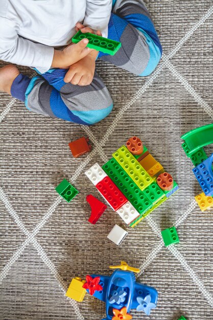 Foto criança brincando com blocos de brinquedo sentada no chão