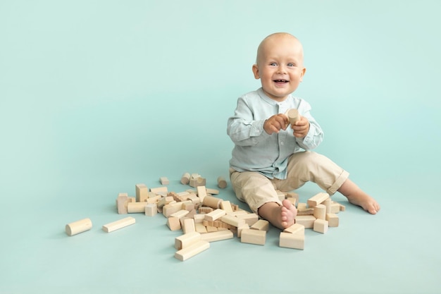 Criança brincando com blocos de cubos de madeira em fundo azul Copiar espaço Jogo educacional Montessori Conceito de brinquedos de madeira não plástico Desenvolvimento infantil Estilo de vida ecológico minimalista