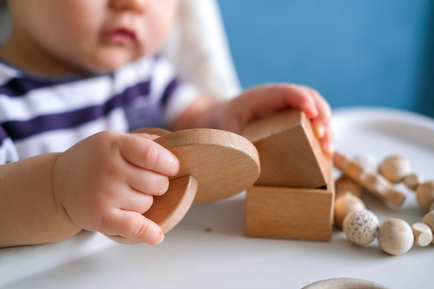 Criança brincando com brinquedos de madeira na cadeira de Papa