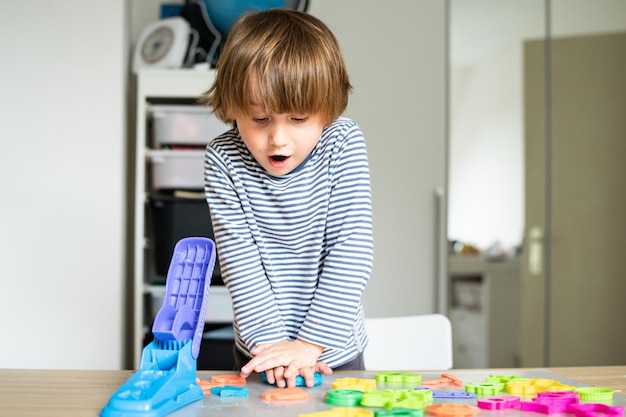 Criança brincando com composto de modelagem definido em casa Jogo criativo de desenvolvimento inicial infantil