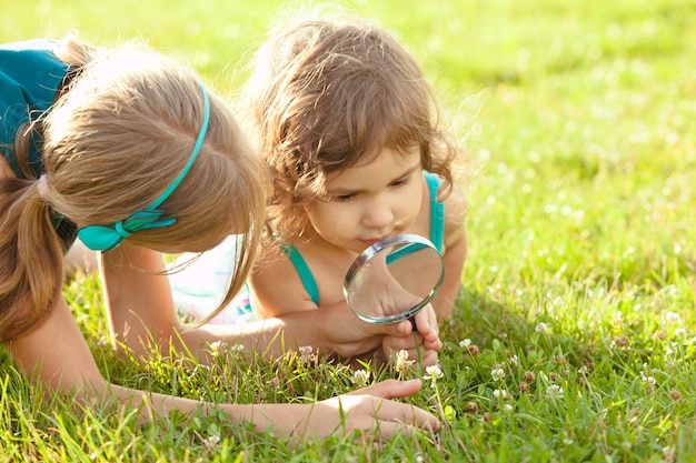 Criança brincando com lupa no jardim