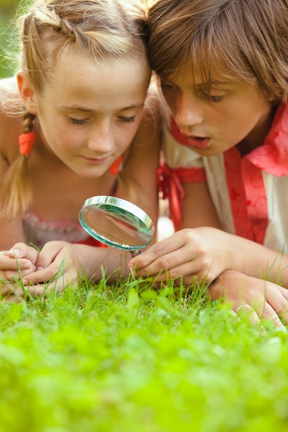 Criança brincando com lupa no jardim