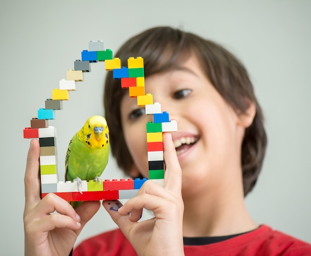 Foto criança brincando com o papagaio de seu animal de estimação