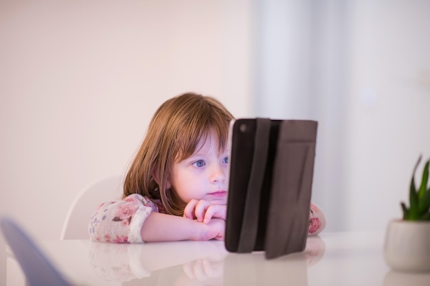 criança brincando com tablet digital em casa