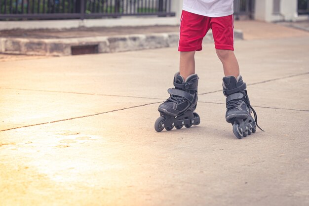 Criança brincando de patins na estrada de cimento