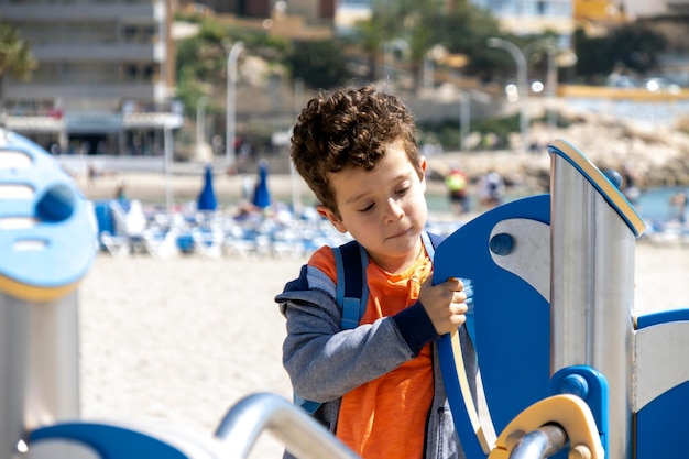 Criança brincando em playground localizado na praia