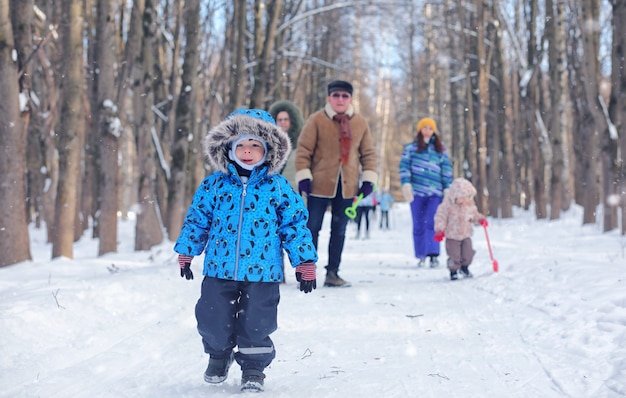 Criança brincando em um parque de inverno e se divertindo com a família