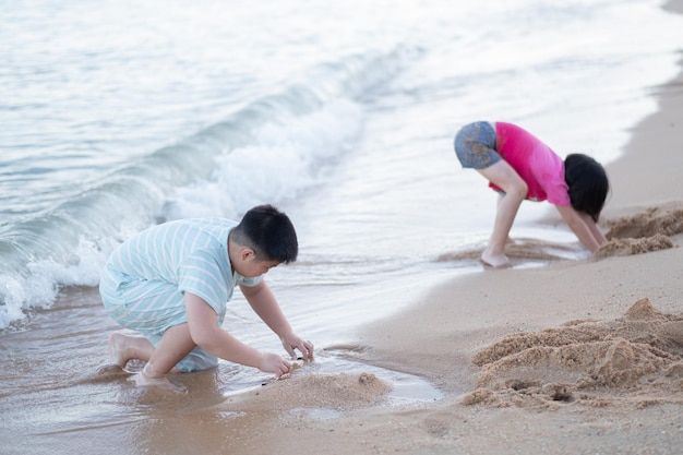 Criança brincando na areia na praia, crianças brincando no mar