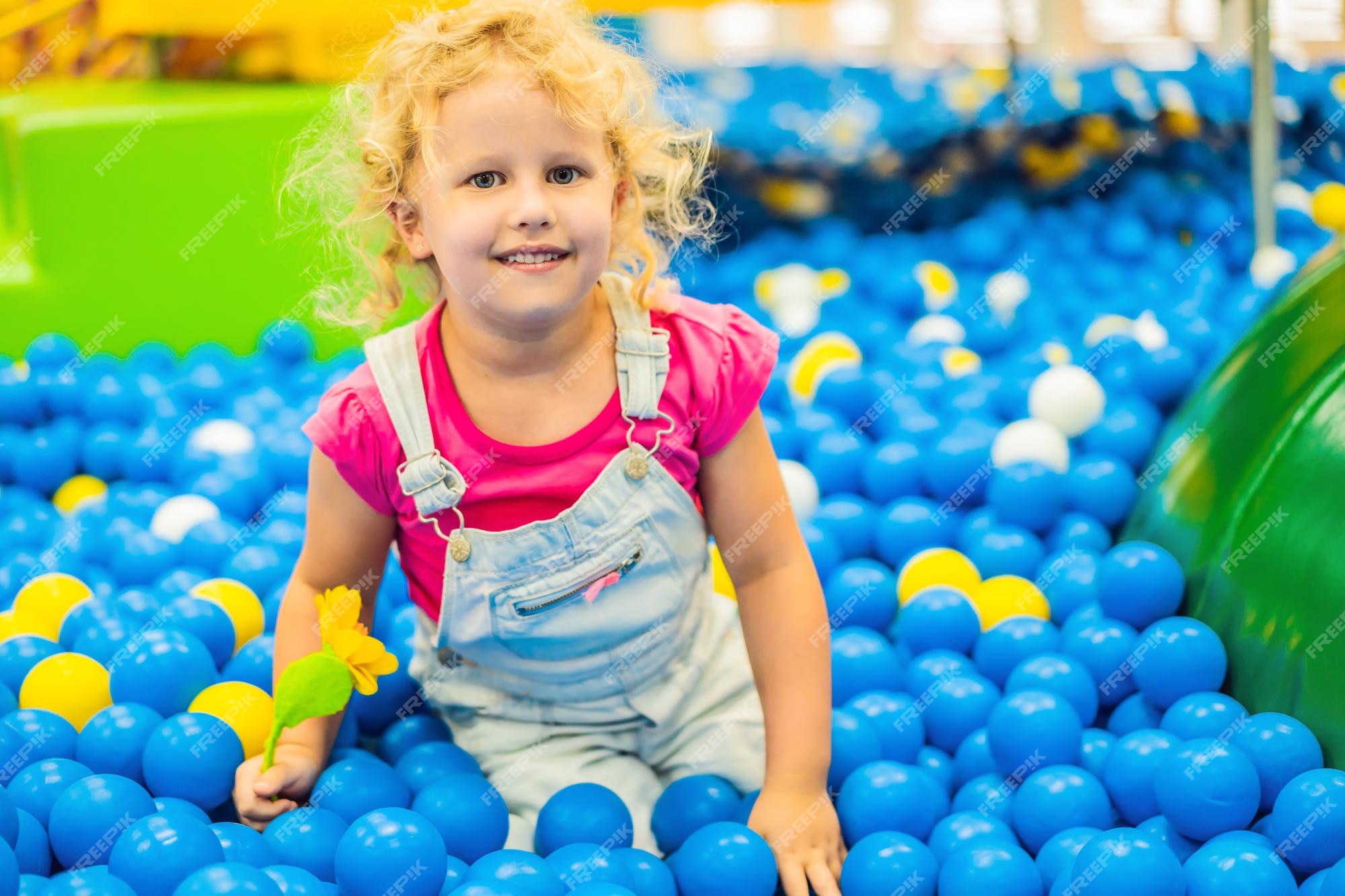 irmão com irmã jogando na piscina de bolinhas coloridas. playground interno  de creche. piscina de bolinhas para crianças. sala de jogos do jardim de  infância ou pré-escola. 5848214 Foto de stock no