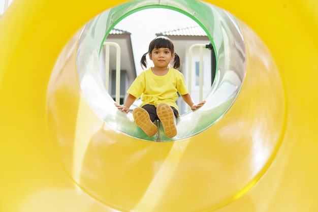 Criança brincando no playground ao ar livre. as crianças brincam no pátio da escola ou do jardim de infância.