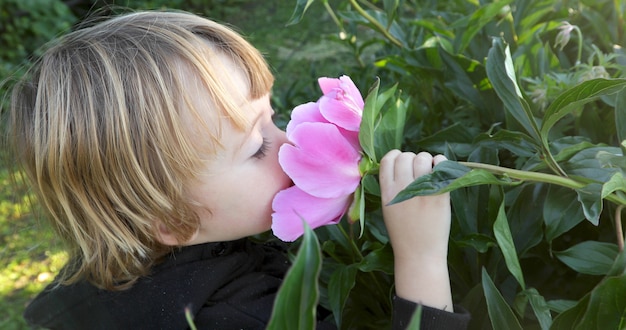 Criança cheira uma flor