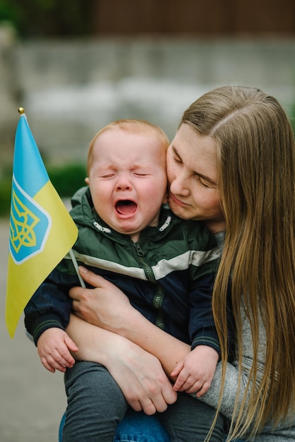 Criança chorando e pede para parar a guerra na Ucrânia Família e povo levantam bandeira amarela e azul Ucrânia Sem guerra para a agressão russa Pedindo paz crianças contra crianças de guerra em perigo