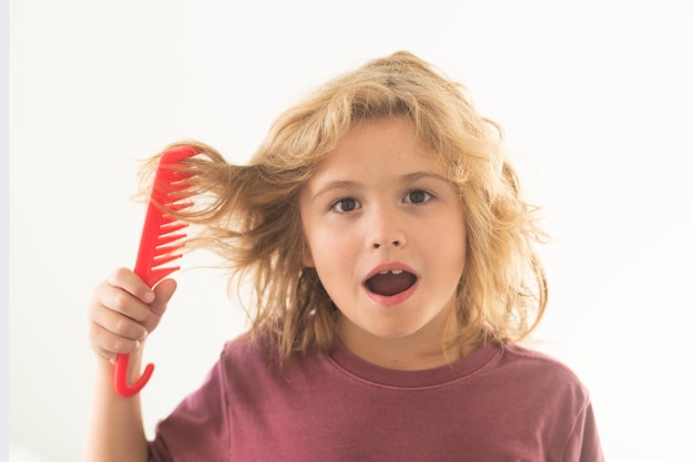 Criança com cabelo encaracolado segura escova de cabelo ou penteia cabelo saudável criança escovando cabelo rebelde emaranhado