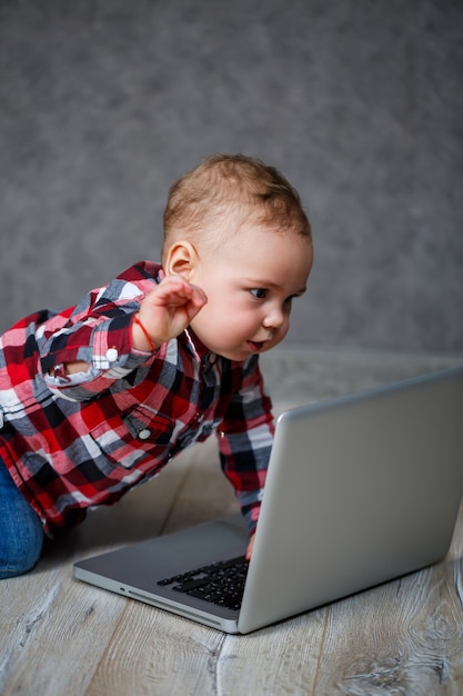 Criança com camisa brincando com laptop