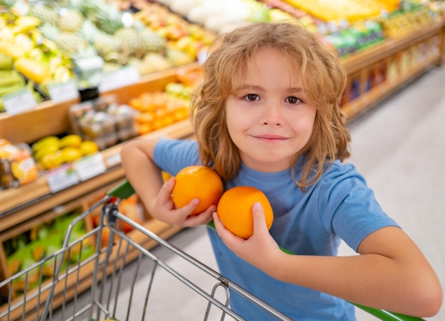 Criança com cesta de compras com garoto de mercearia comprando mantimentos no menino de supermercado no conceito de loja de s