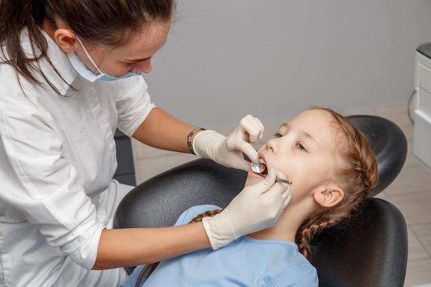 Criança com check-up odontológico por especialista em consultório dentário