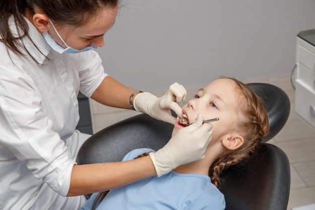 Criança com check-up odontológico por especialista em consultório dentário