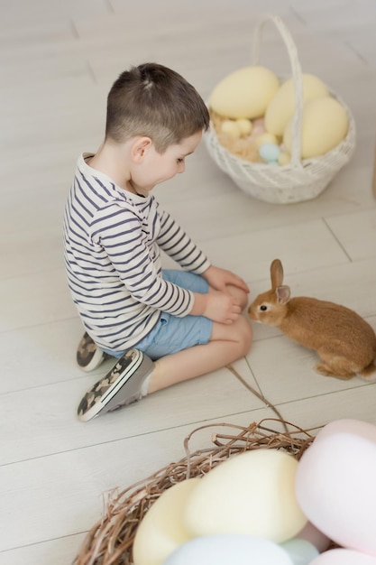 Criança com coelho e decoração de Páscoa