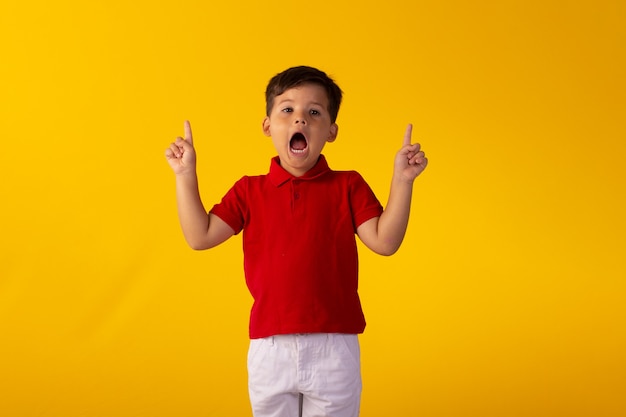 Criança com expressões faciais em uma foto de estúdio sobre fundo colorido.