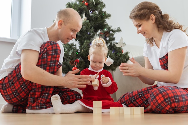 Criança com implante coclear brinca com os pais sob a surdez da árvore de natal e tecnologias médicas inovadoras para aparelhos auditivos e diversidade