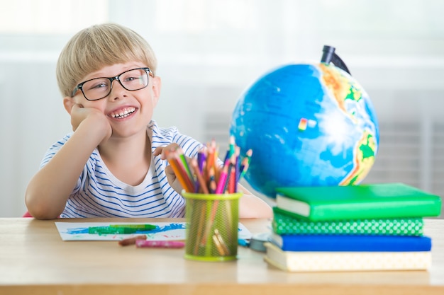 Criança com livros e globo aprendendo lições