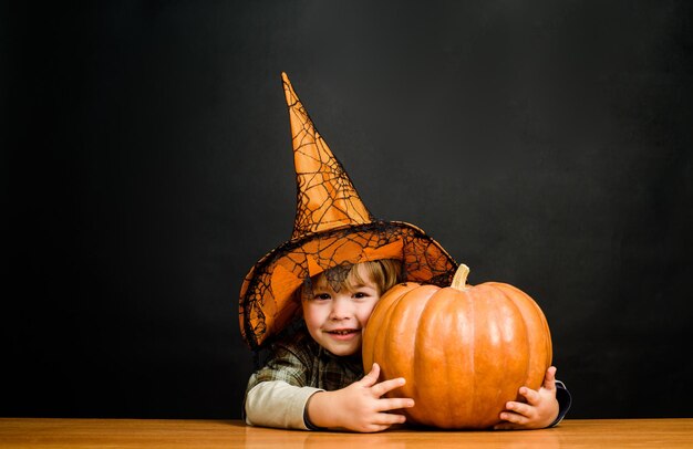 Criança com menino abóbora vestida de truque ou travessura feliz festa de halloween de halloween menino em