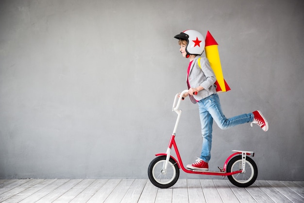 Criança com mochila a jato. Criança brincando em casa. Conceito de tecnologia de sucesso, imaginação e inovação