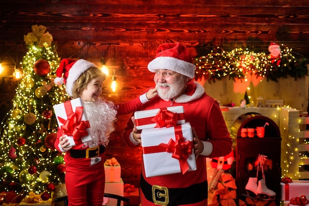 Criança com papai noel e presente de natal em casa papai noel e criança com natal