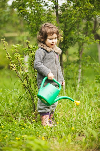 Criança com regador no jardim