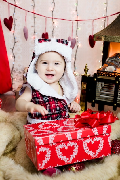 Criança com roupas de ano novo, passa o tempo na árvore de natal