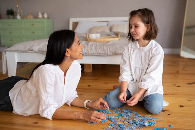 Foto criança com sua mãe jogando um quebra-cabeças