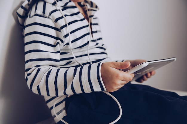 Criança com tablet sentado no chão