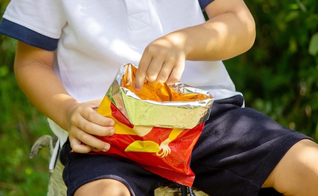 Criança come batatas fritas.