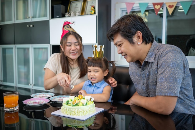 Criança comemorando festa de aniversário Velas de aniversário bordadas e bolo de corte para compartilhar