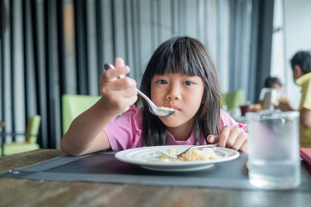 Criança comendo comida feliz no café da manhã