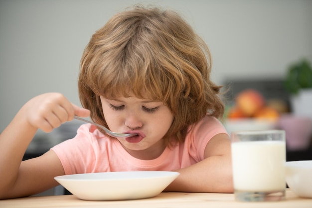 Criança comendo comida saudável em casa, bebê, tomando sopa com colher