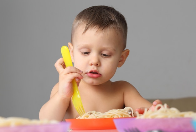 Criança comendo macarrão