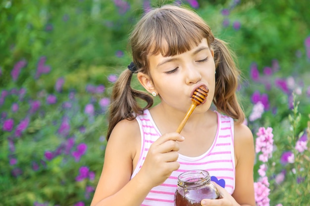 Criança comendo mel, foto de verão