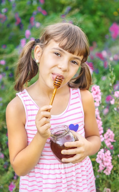 Criança comendo mel, foto de verão